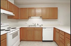 Pine Island townhouse for rent - an empty kitchen with wooden cabinets and white appliances