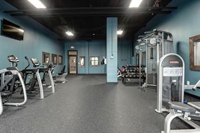 Manassas Park apartment for rent - a gym with weights and other equipment in a building with blue walls