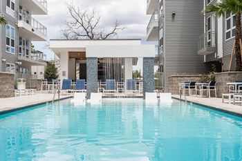 Pool and sundeck with social area, fire pit, and bar