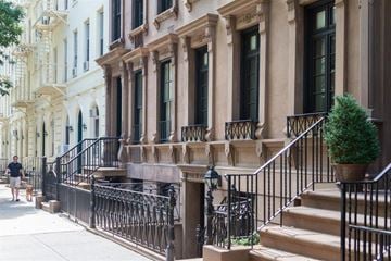 New York apartment for rent - a man walking down the sidewalk in front of a building