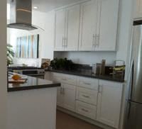 Los Angeles apartment for rent - a kitchen with white cabinets and a black counter top