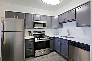 Tempe apartment for rent - a kitchen with stainless steel appliances and black and white cabinets