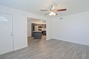 Tempe apartment for rent - an empty living room with a ceiling fan and a kitchen