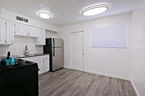 Phoenix apartment for rent - an empty kitchen with white cabinets and a black refrigerator