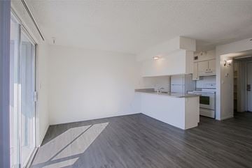 Phoenix apartment for rent - the living room and kitchen of an apartment with white walls and wood flooring