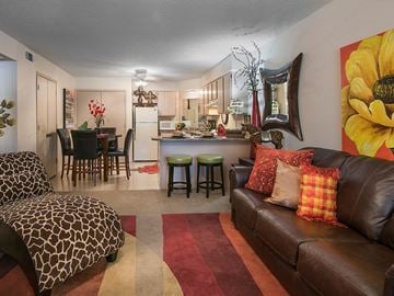 Jonesboro apartment for rent - a living room with a leather couch and a kitchen with a table and chairs
