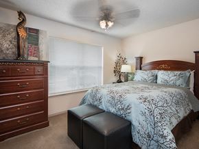 Jonesboro apartment for rent - a bedroom with a bed and a dresser and a ceiling fan