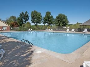 Harrison apartment for rent - a swimming pool with chairs and trees in the background