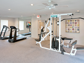 Siloam Springs apartment for rent - a gym with cardio equipment and a ceiling fan in a home gym