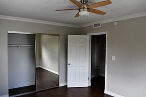 Hollywood apartment for rent - View of bedroom with wood look flooring, sliding glass mirror closet, and ceiling fan