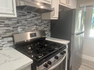 Hollywood apartment for rent - A kitchen with a black stove top oven and a black refrigerator.