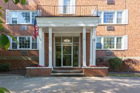 Shaker Heights apartment for rent - the front door of a brick building with an flag