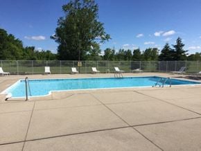 Mt. Morris townhouse for rent - a swimming pool with white chairs around it