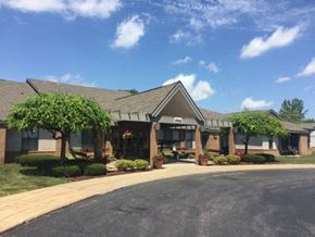 Saginaw apartment for rent - a view of the front of a brick building with trees and a driveway