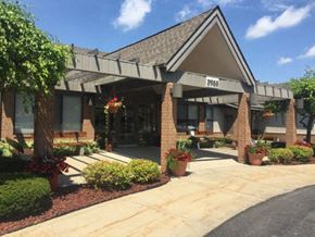 Saginaw apartment for rent - the front of a building with potted plants and a sidewalk