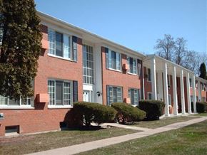 Flushing townhouse for rent - a large brick building with white columns