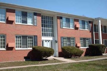 Flushing townhouse for rent - a large brick building with a lawn in front of it