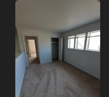 Grand Blanc condo for rent - a living room with a carpet and a door to a hallway