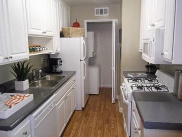 Simi Valley apartment for rent - A kitchen with white cabinets and a white fridge.