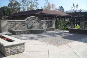 Simi Valley apartment for rent - A stone monument with a plaque on it is in front of a building.