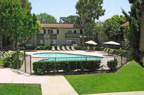 Simi Valley apartment for rent - A pool surrounded by a black fence and trees.