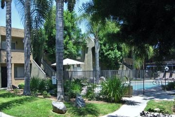 Poway apartment for rent - A pool surrounded by a fence and trees.