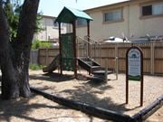 Poway apartment for rent - A playground with a green roofed structure and a slide.