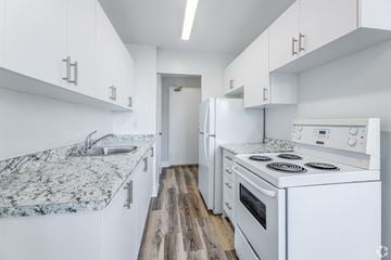Toronto apartment for rent - A kitchen with white cabinets and a granite countertop.