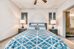 Conroe apartment for rent - a bedroom with a large bed and a ceiling fan