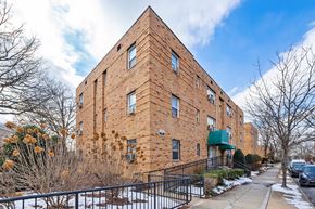 Washington apartment for rent - A brick building with a green awning and a black fence.