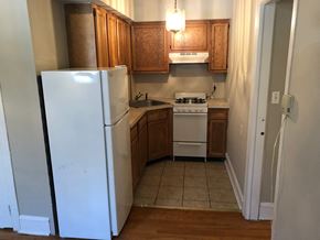 Philadelphia apartment for rent - a kitchen with a refrigerator and a stove and cabinets