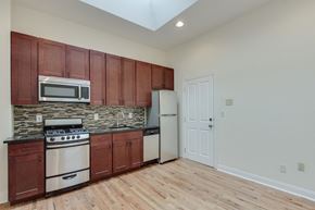Philadelphia apartment for rent - an empty kitchen with a stove refrigerator and microwave