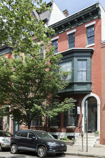 Philadelphia apartment for rent - a car parked in front of a house on a city street