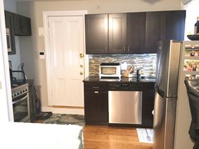 Philadelphia apartment for rent - a small kitchen with stainless steel appliances and black cabinets