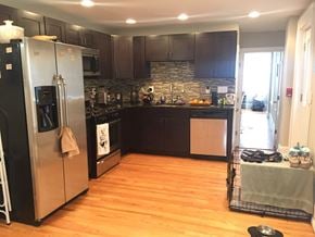 Philadelphia apartment for rent - a kitchen with black cabinets and stainless steel appliances and a wooden floor