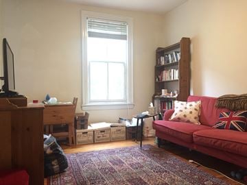 Philadelphia apartment for rent - a living room with a red couch and a window