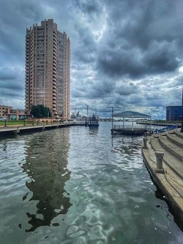 Portsmouth apartment for rent - A tall building stands next to a body of water under a cloudy sky.