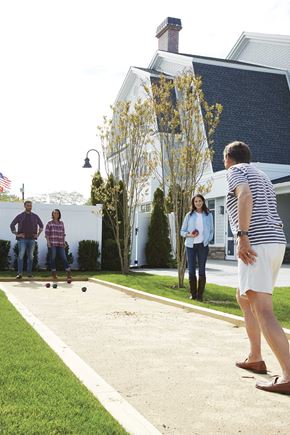 Amityville apartment for rent - a group of people playing bocce in front of a house