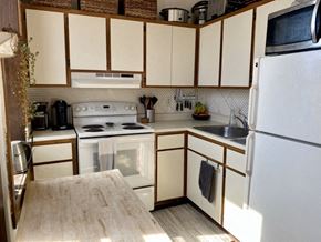 Madison apartment for rent - a kitchen with white appliances and wooden cabinets