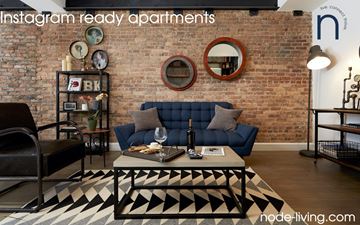 Brooklyn apartment for rent - A living room with a brick wall and a black and white rug.