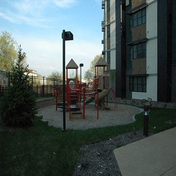 Minneapolis apartment for rent - A playground with a red slide and a brown swing set.