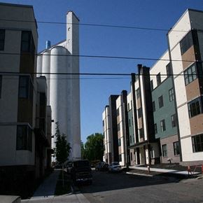Minneapolis apartment for rent - A tall white silo stands in front of a row of modern buildings.