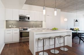 West Hollywood apartment for rent - a modern kitchen with a white island and bar stools