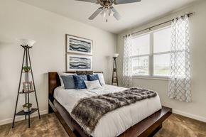 Fort Worth apartment for rent - A bedroom with a large bed and a ceiling fan.