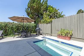 North Hollywood apartment for rent - a backyard with a pool and a fence and a table and umbrella