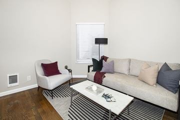 San Francisco apartment for rent - A living room with a white chair, a white coffee table, and a beige couch with pillows.