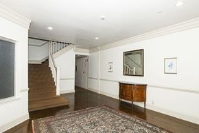 San Francisco apartment for rent - A hallway with a rug on the floor and a wooden cabinet.