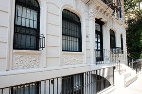 New York apartment for rent - the facade of a building with barred windows and stairs