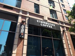 New York apartment for rent - a starbucks coffee sign in front of a brick building