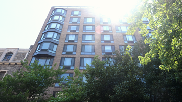 New York apartment for rent - a tall brick building with trees in front of it